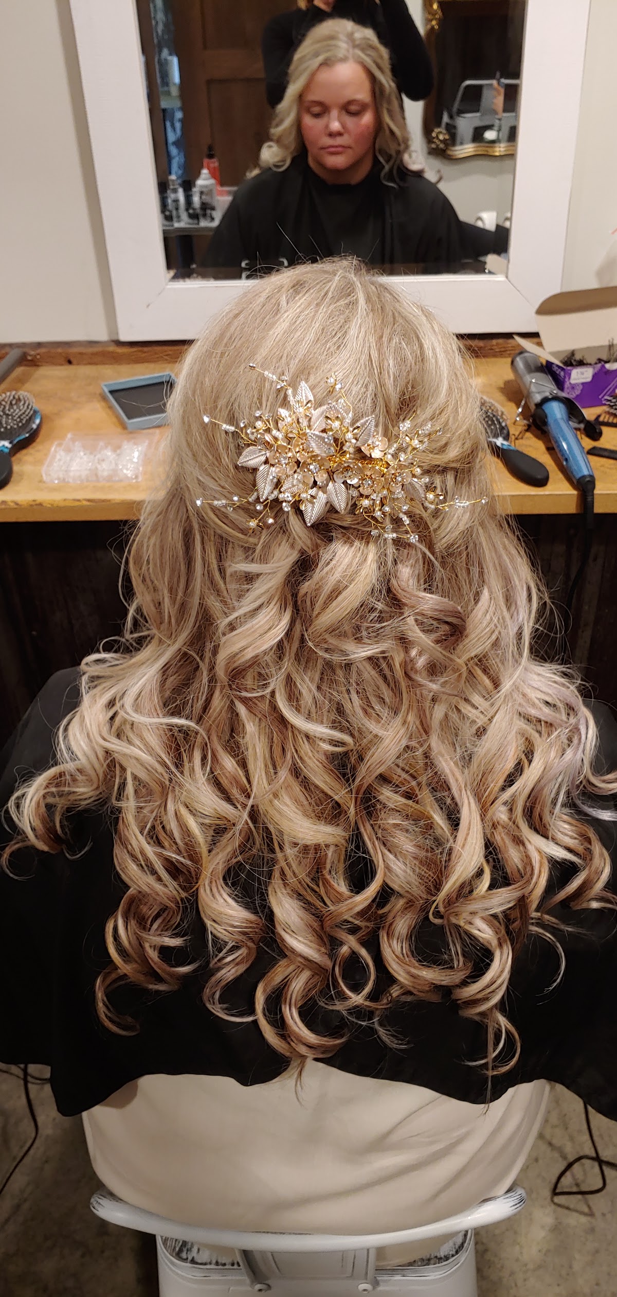 Half-up curled updo with a bridal hair accessory