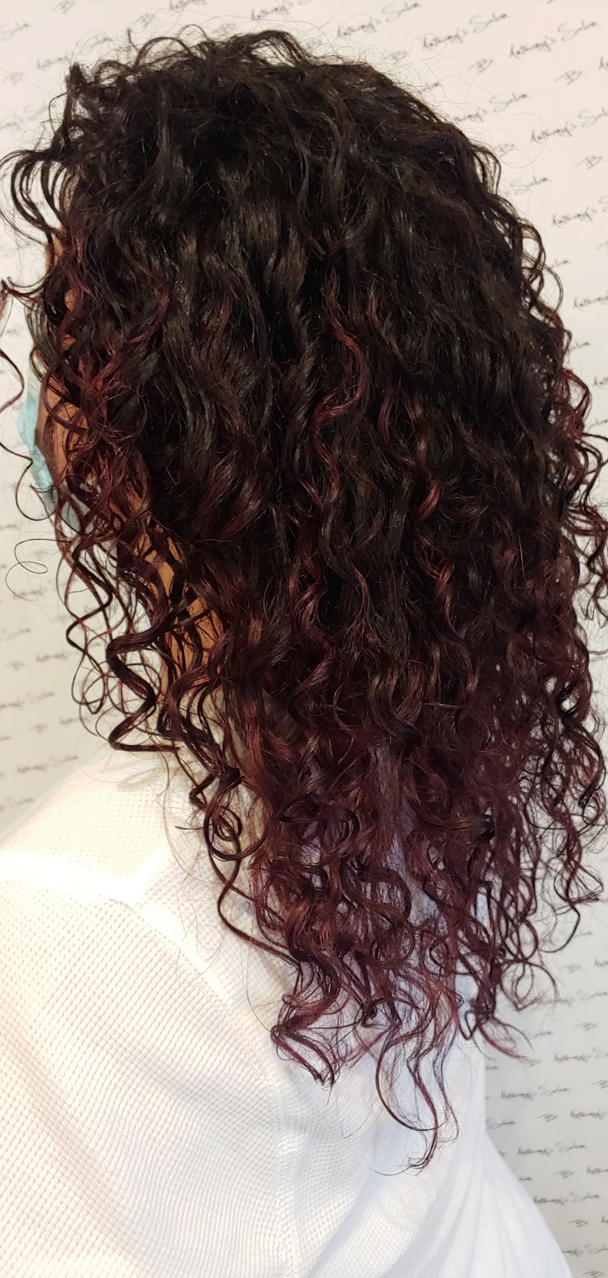 Dark curly hair with deep red balayage