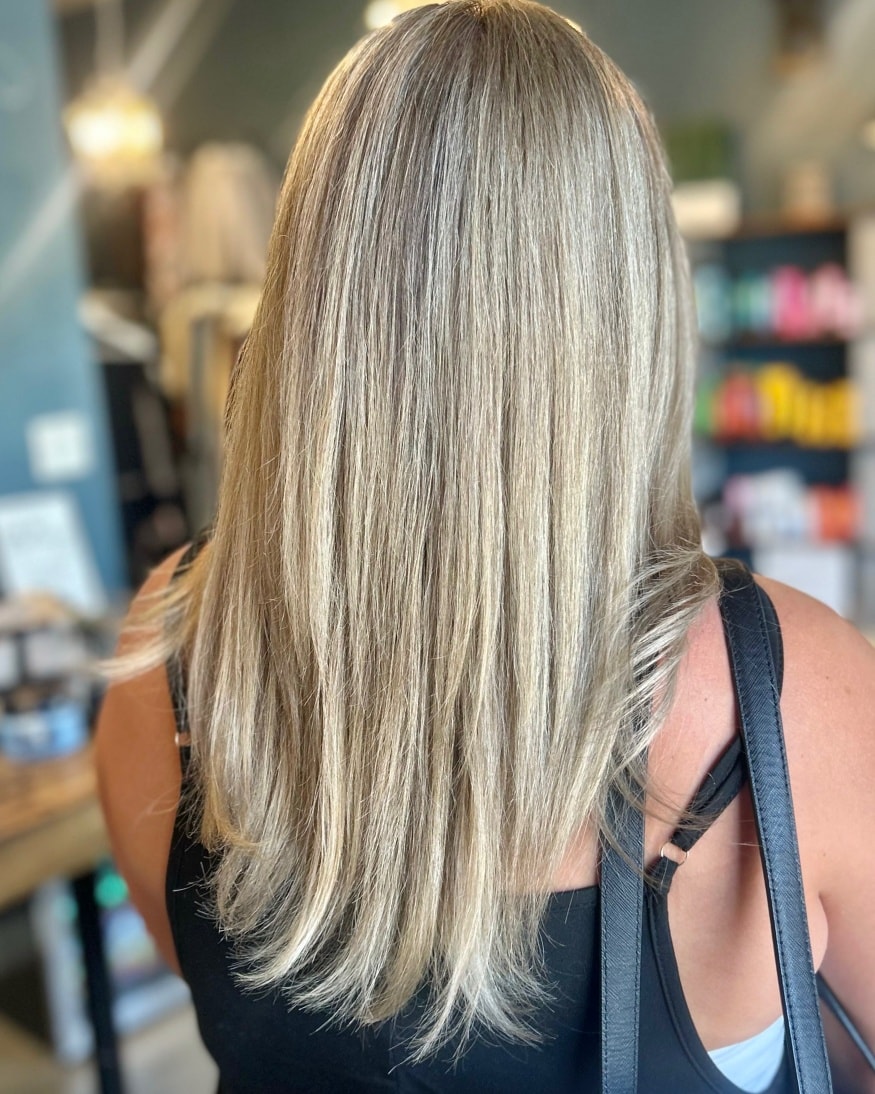 Straight blonde balayage near the retail shelving