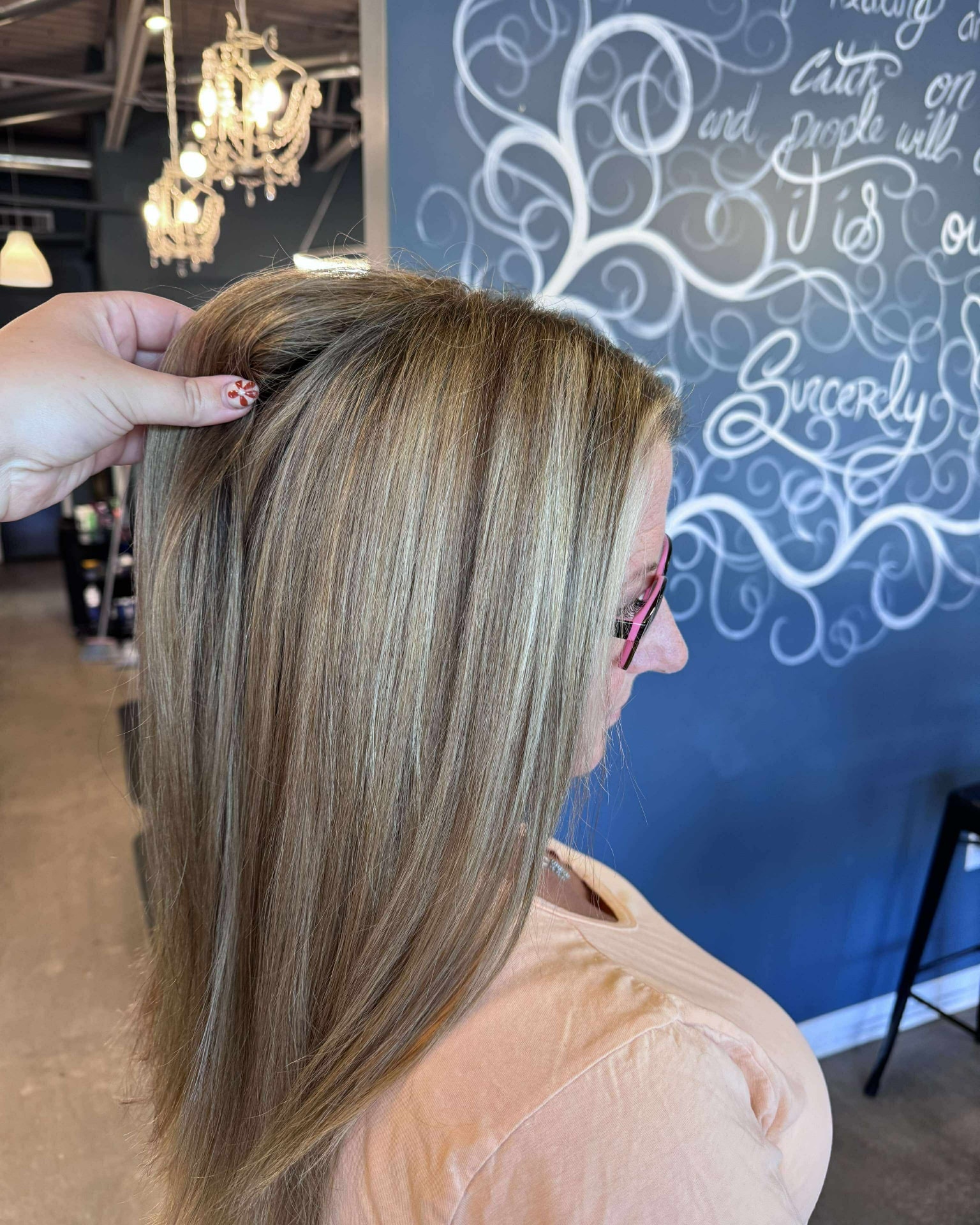 Stylist checking freshly lifted blonde highlights